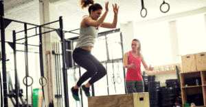 trainer-with-a-client-doing-box-jumps-in-a-gym