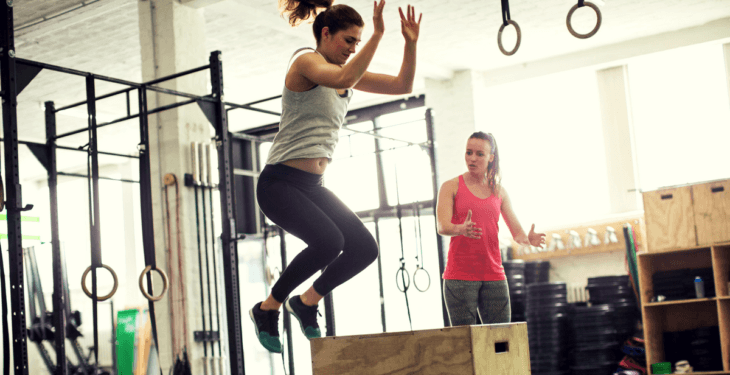 trainer-with-a-client-doing-box-jumps-in-a-gym
