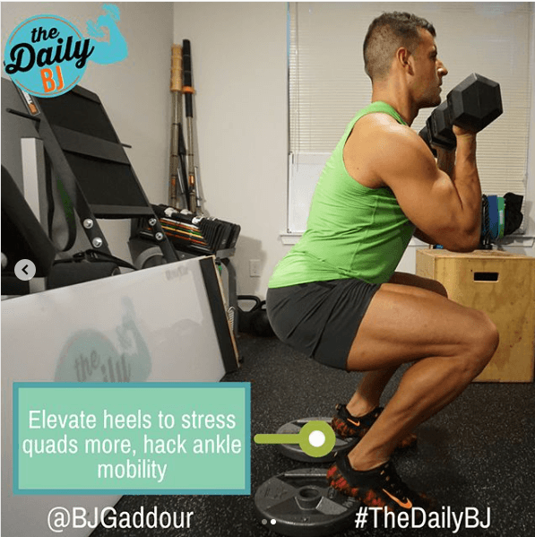 BJ-Gaddour-doing-a-dumbbell-squat-with-heels-elevated-on-weight-plates-to-stress-quads-more-and-hack-ankle-mobility